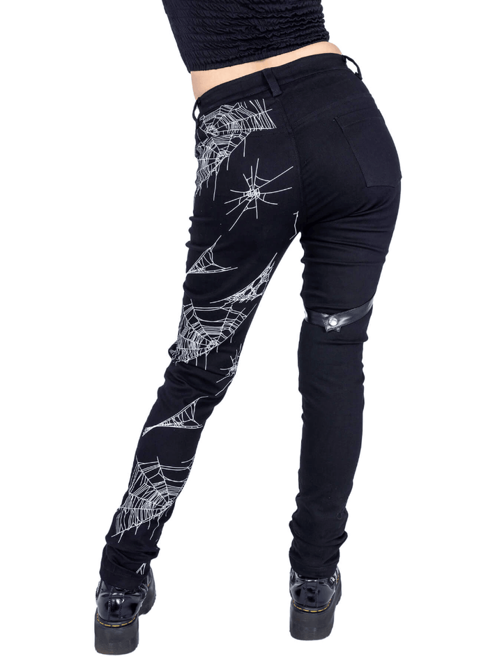 Death Rocker punk jeans in black stretch denim, detailed with an all‑over spider web pattern, removable harness strap design, and back pockets, made of 58% cotton, 39% polyester, 3% elastane — perfect for edgy streetwear.
