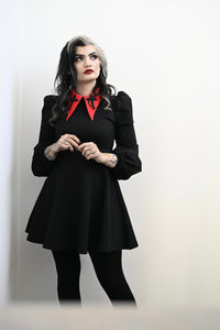 Delight in the gothic-chic charm of this black Baptism Dress, featuring a bold pointed collar with subtle cross embroidery that adds a unique touch. Pick between a timeless black collar or a bright red one to suit your style. With puffed shoulders and flowing bishop sleeves, this dress combines drama and sophistication, made from high-quality thick ponte fabric that is soft, stretchy, and perfect for cooler weather.