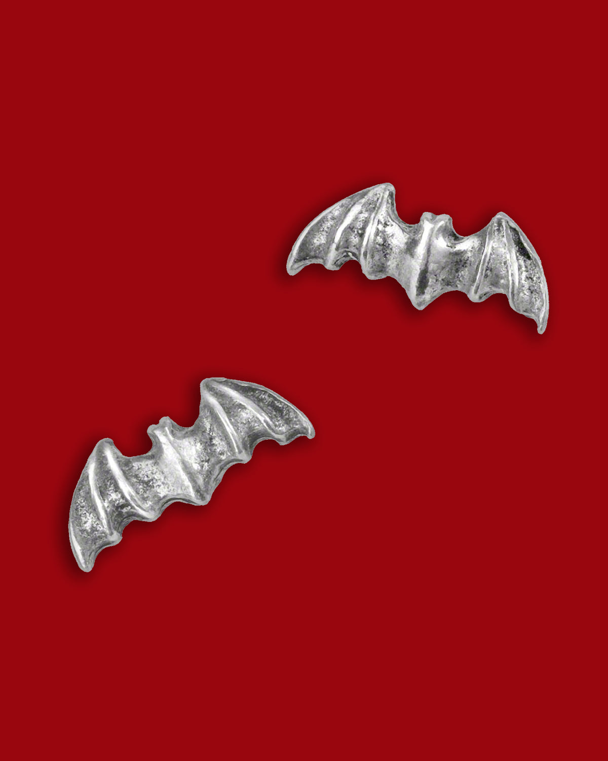 A pair of finely crafted bat‑wing stud earrings in English pewter with surgical steel posts, designed for subtle gothic elegance—perfect for everyday wear or adding nocturnal charm to any outfit. With an approximate width of 0.51″ and a height of 0.20″, these earrings offer a sleek silhouette that balances dark symbolism and minimalist design. Hypoallergenic and compliant with jewelry safety standards, they bring a discreet yet edgy accent to playlists of gothic accessories and modern wardrobes alike.