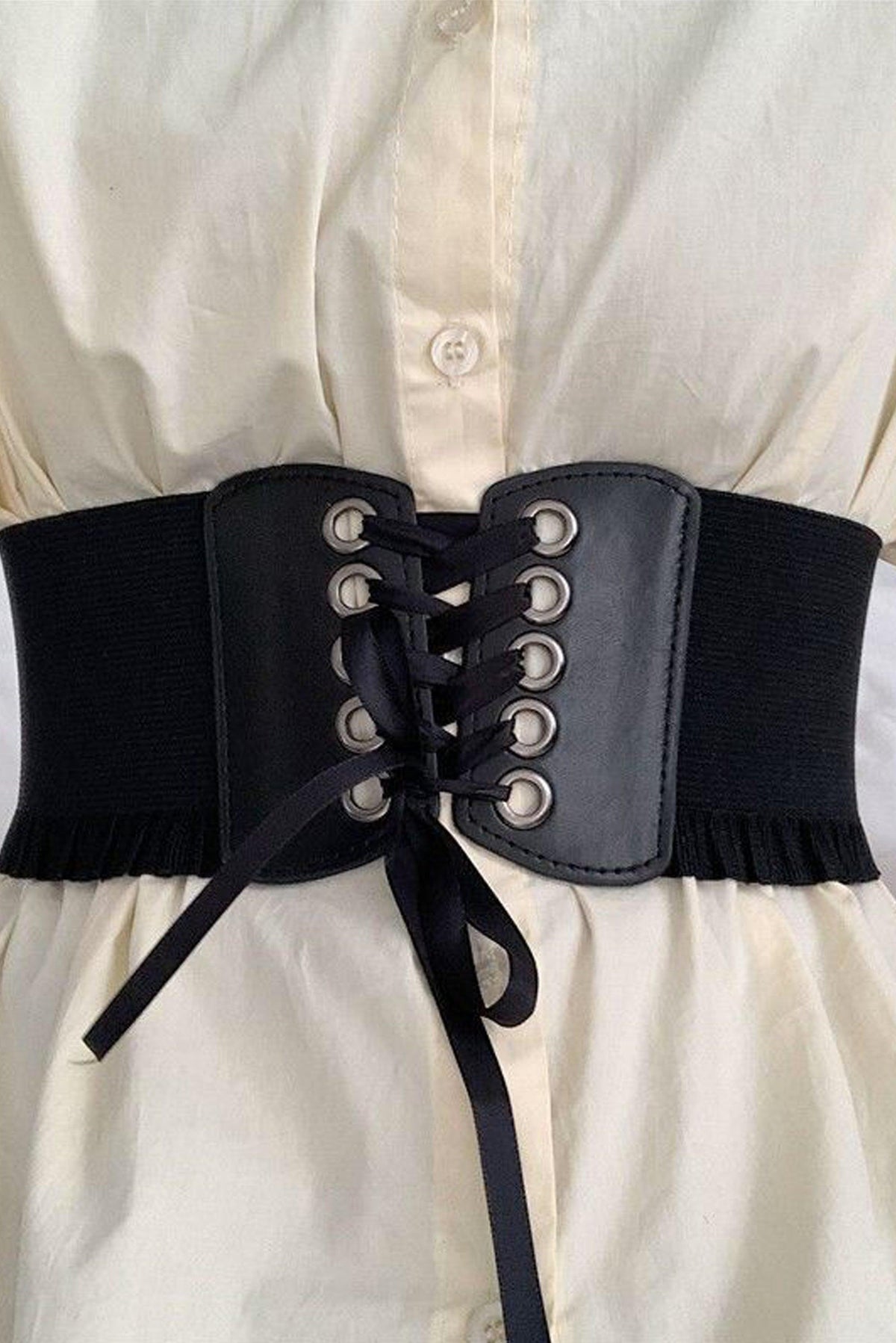 Fashion-forward high-waisted corset belt featuring a lace-up front with metal eyelets, flexible stretch sides for comfort, and a bold silhouette-enhancing design, suitable for layering over dresses, tunics, or shirts to add edgy and stylish flair to any outfit.