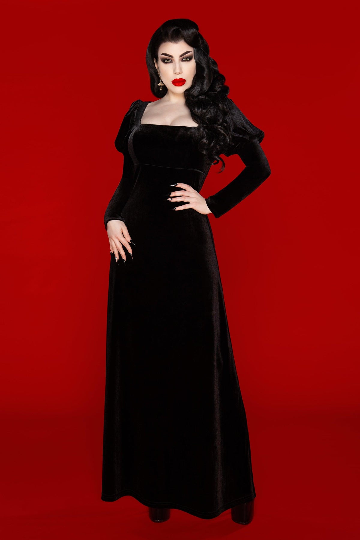 The Daphne Dress is a luxurious black velvet gown inspired by Regency-era elegance and Audrey Hepburn’s timeless look in War and Peace. Crafted from soft, stretchy polyester velvet, this dress embodies dark sophistication with its empire waist, puffed Victorian long sleeves, and flattering scoop neckline that highlights the décolletage. Perfect for gothic fashion lovers seeking a romantic yet refined alternative look.