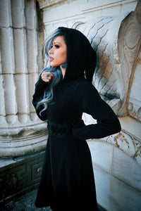 A gothic-inspired, full-length black cardigan with a fitted, laced bodice and structured edges, made of 100% polyacrylic, featuring a front zip closure, oversized hood, high-low hem for dramatic flow, and thumbholes, ideal for creating moody, layered alternative fashion ensembles.