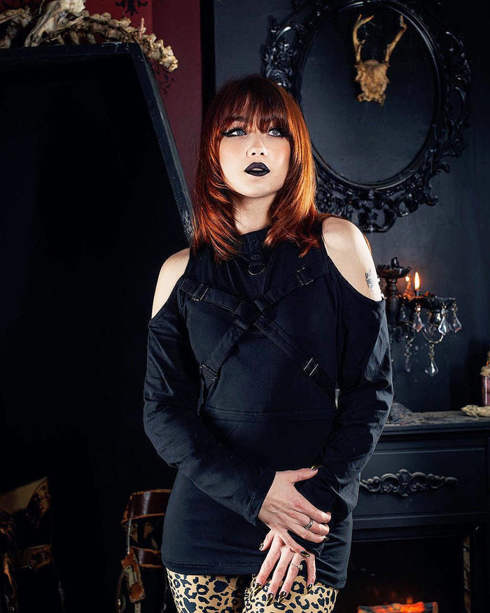 Model posing a in gothic decorated room wearing the Anidori Top and leopard print pants.