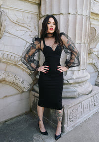 Sheer Gothic blouse crafted from stiff, see-through chiffon, featuring dramatically oversized puffy sleeves, high structured shoulders, and a tall collar, designed with a button-up back closure to create a bold couture-inspired silhouette perfect for elegant eveningwear or alternative fashion styling.