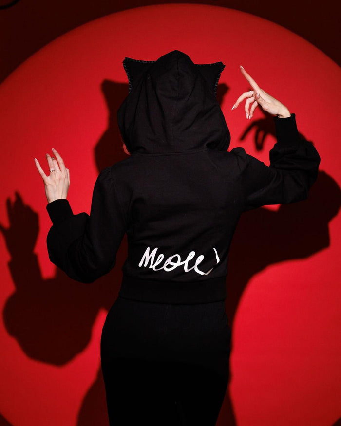 Stylish Meow Kitty Sweater with dramatic puffed sleeves, playful heart-striped pockets, skull zipper pull, and bold 'Meow' lettering on the back, embodying 2000s emo and scene fashion trends for unique statement outfits