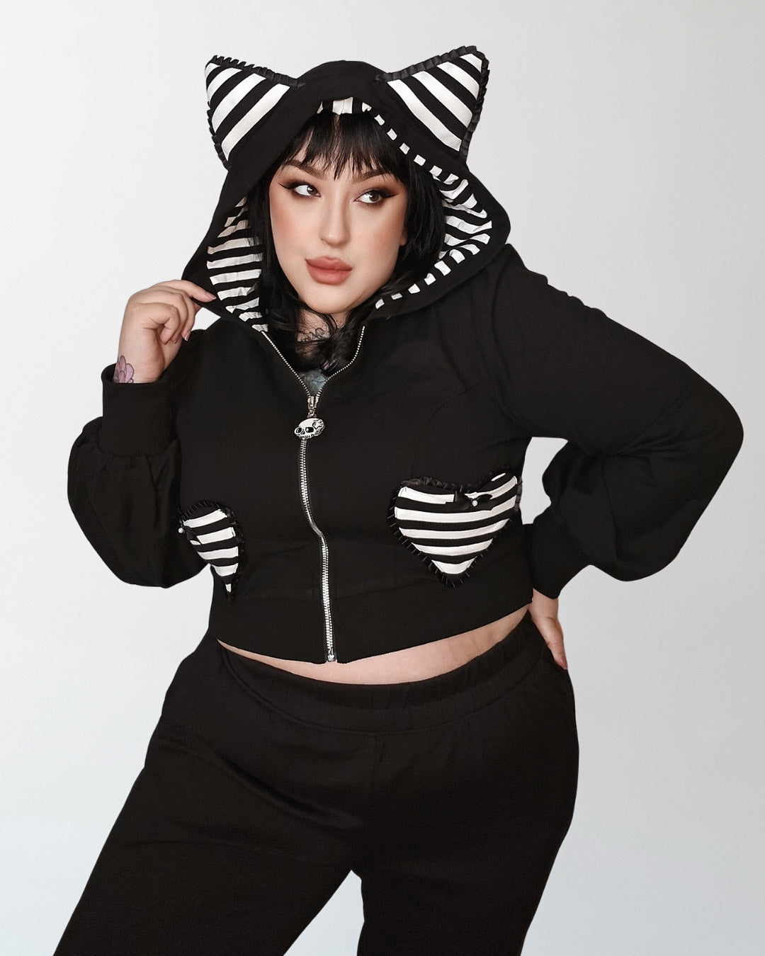 Meow Kitty Sweater in black with dramatic puff sleeves, whimsical striped cat ears, heart-shaped pockets, and a bold back 'Meow' print, designed by Jessica Louise Clothing & Katakomb for nostalgic 2000s scene fashion enthusiasts.