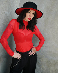 A stylish sheer red turtleneck made from lightweight mesh fabric, perfect for layering or wearing on its own. The top features a high neckline and long sleeves that create a sleek, timeless look. It adds a hint of mystery and sophistication whether paired under a dress, a corset, or a jacket. Ideal for anyone who loves a chic, modern aesthetic.