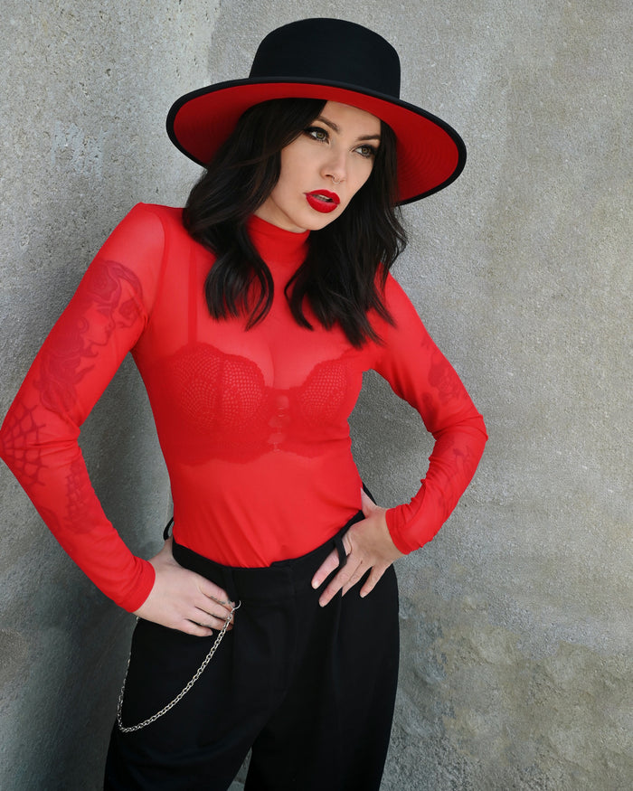 A stylish sheer red turtleneck made from lightweight mesh fabric, perfect for layering or wearing on its own. The top features a high neckline and long sleeves that create a sleek, timeless look. It adds a hint of mystery and sophistication whether paired under a dress, a corset, or a jacket. Ideal for anyone who loves a chic, modern aesthetic.