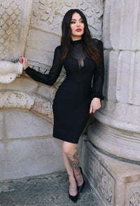 Sleek and elegant black Mistress Dress with a figure-hugging bengaline fabric, sheer mesh neckline, and voluminous bishop sleeves, offering a mysterious yet sophisticated look ideal for gothic wardrobes, special occasions, or commanding a striking presence at evening events.