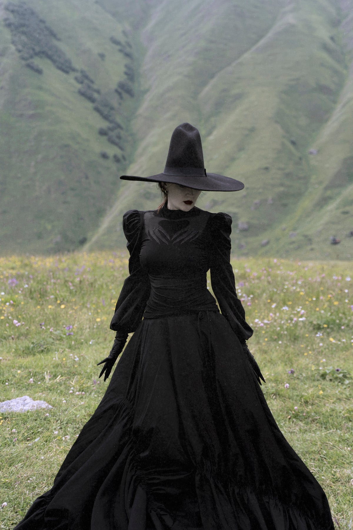 Black Phantom Blouse made with high-stretch polyester for movement and comfort, showcasing a sheer mesh chest cut-out with Naya’s haunting hand design, dramatic puff shoulders, and long gathered sleeves for a gothic, spellbinding style.