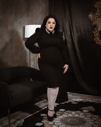 A chic black long-sleeve dress with a structured fit and a sparkling embellished collar. The design combines sophistication with vintage-inspired charm, making it a versatile piece for both formal and evening occasions.