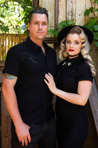 Crafted from premium black bengaline, the Wayne Shirt redefines western style through a gothic lens. Its structured fabric provides a sculpted fit, while vegan leather piping adds contrast and dimension along the chest and sleeves. Finished with matte black snap buttons and removable silver collar tips, this shirt combines practicality with statement-making design. Ideal for gothic fashion lovers or anyone drawn to dark, modern interpretations of classic western silhouettes.