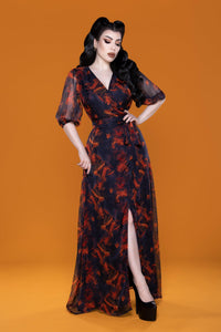 Winona Maxi Dress in lightweight chiffon featuring a new Autumn Leaves Print. This floor-length dress has a classic front wrap style, V-shaped neckline, flared bishop sleeves, and a flowing skirt, offering versatile comfort and elegance for both casual daytime outings and polished evening events.