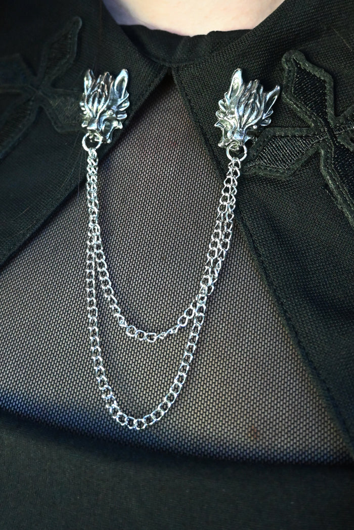 Gothic wolf head collar clip in polished silver metal with dual chain links for stylish draped effect. Ideal for dark fashion looks on blazers, coats, or heavy fabric accessories.