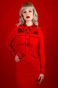 The June Dress in red merges the worlds of gothic western and vintage rockabilly fashion, offering intricate embroidery, polished pleather piping, and long piped sleeves. With its seamless fixed snaps and stretch bengaline construction, this dress provides both structure and flexibility for a uniquely elegant and rebellious aesthetic.