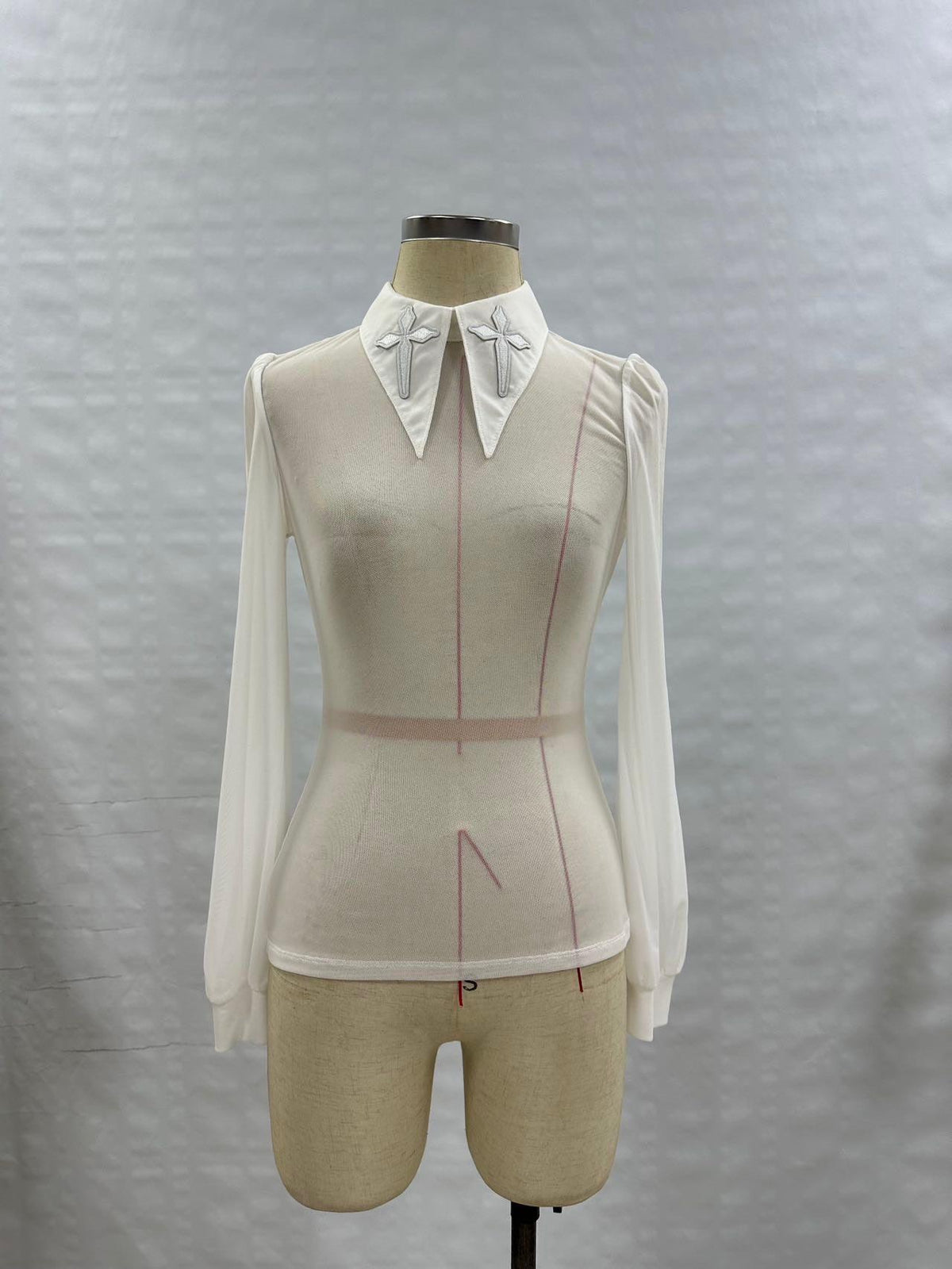 Gothic-inspired Personal Jesus top featuring long sleeves, semi-transparent soft mesh material, oversized embroidered crosses on an extended pointy collar, subtle back keyhole detail, and stretchy fabric for movement, perfect for edgy streetwear, festival styling, and club-ready fashion.