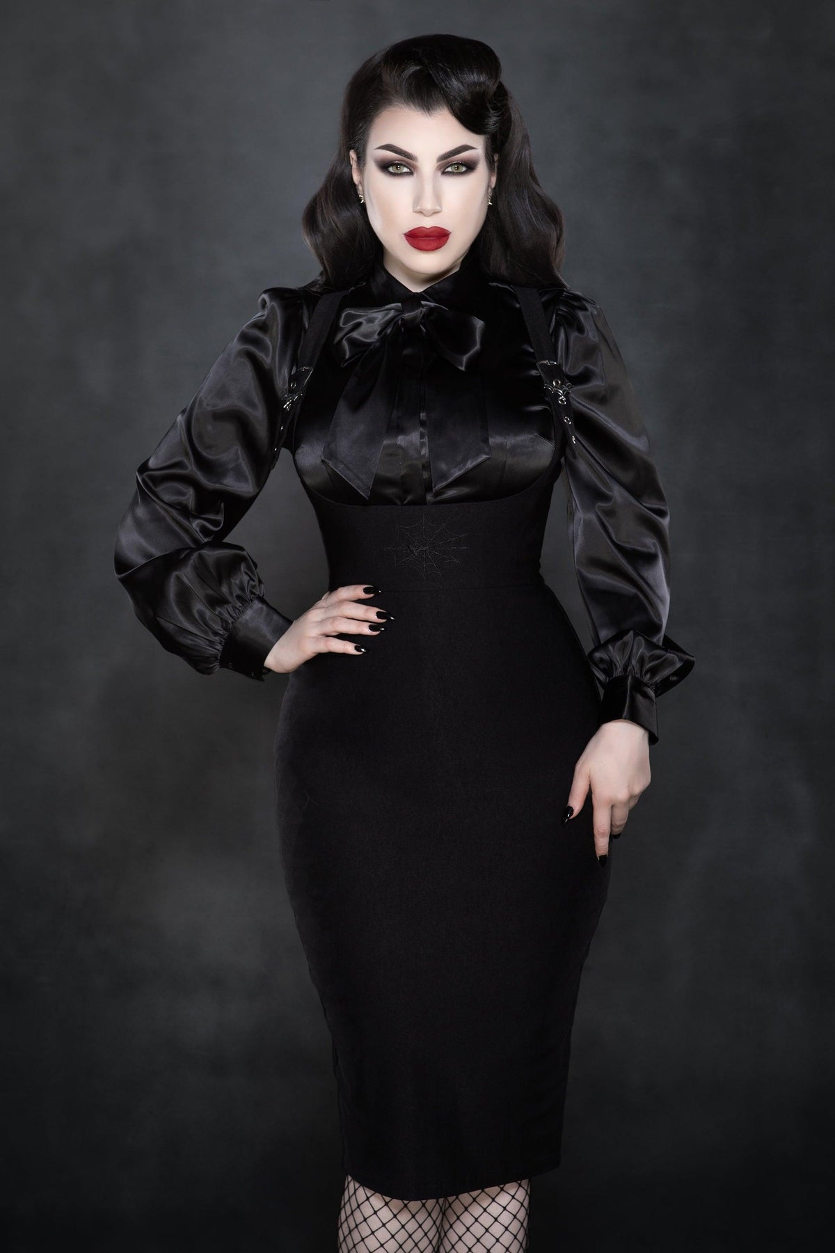 Elegant and edgy, the black Webbed Suspender Skirt is crafted from premium Bengaline fabric for a sleek, form-fitting silhouette. Featuring bold shoulder-framing suspenders and a custom spider web buckle, this gothic-inspired skirt blends sophistication with alternative fashion flair. The subtle embroidered black web at the waist adds a mysterious, refined touch perfect for versatile styling from day to night.