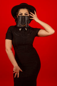With its sleek, form-fitting silhouette and premium Bengaline fabric, the Wanda Pencil Dress delivers comfort and elegance in one timeless black design. Featuring updated snap detailing, faux front snaps, and a smooth back zipper, it combines classic femininity with a touch of Western-inspired charm through its removable silver collar clips and stylish pleather piping, perfect for day-to-night transitions.