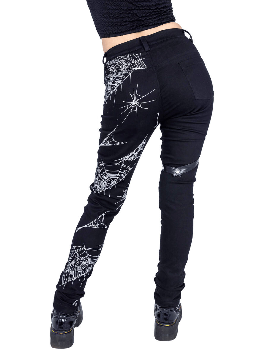 Death Rocker punk jeans in black stretch denim, detailed with an all‑over spider web pattern, removable harness strap design, and back pockets, made of 58% cotton, 39% polyester, 3% elastane — perfect for edgy streetwear.