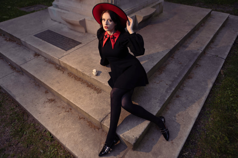 Make every moment magical with this black Baptism Dress, complete with a large pointed collar accented with gentle cross embroidery. The dress comes with a choice of a solid black or vibrant red collar, creating either a refined or eye-catching look. Dramatic puffed shoulders and soft bishop sleeves give the dress a sense of movement and elegance, while the thick, stretchy ponte fabric ensures your child stays cozy and comfortable throughout the day.