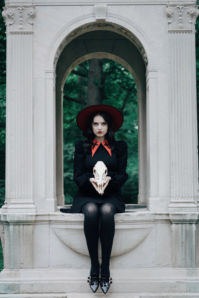 This elegant black Baptism Dress is perfect for creating memorable moments, boasting a large pointed collar delicately embroidered with a cross. Choose a classic black collar for a refined look or a red collar for a cheerful pop of color. The dramatic puff shoulders and bishop sleeves add graceful flair, and the thick, stretchy ponte fabric keeps you comfortable and cozy while providing durability for lasting wear.