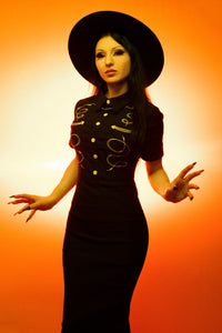 This luxurious black Barbara Dress combines sleek modern tailoring with rugged western influences. Made from flexible Bengaline for comfort and structure, it showcases detailed barbed wire embroidery that traces the front panels with precision. The piped yoke accents highlight the dress’s craftsmanship, while polished snap buttons and a discreet back zipper provide both visual interest and practicality for everyday or evening wear.