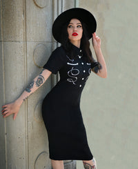 The black Barbara Dress embodies modern western allure with its form-fitting Bengaline fabric and striking embroidered barbed wire motif. Its tailored design includes carefully piped yoke detailing for contour and style, complemented by a row of front snap buttons that enhance its vintage charm. Finished with a concealed zipper in the back, this curve-hugging dress delivers both comfort and structure—ideal for statement looks that merge classic femininity with a bold, barbed-edge aesthetic.