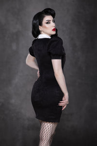 The Bellatrix Dress combines a short, tight black suede silhouette with voluminous puff sleeves and an oversized white collar adorned with intricate black sword embroidery, offering a vintage-inspired gothic alternative dress that balances edgy design, retro charm, and modern fashion appeal for standout occasions.