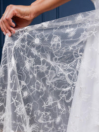 Sophisticated Celestial Dress in black or white embroidered chiffon, featuring a subtle starry constellation print, sparkly shimmer, low-cut neckline, and cross-strap accents. Perfect for special occasions, evening celebrations, or formal gatherings, this maxi dress combines modern chic with timeless elegance.