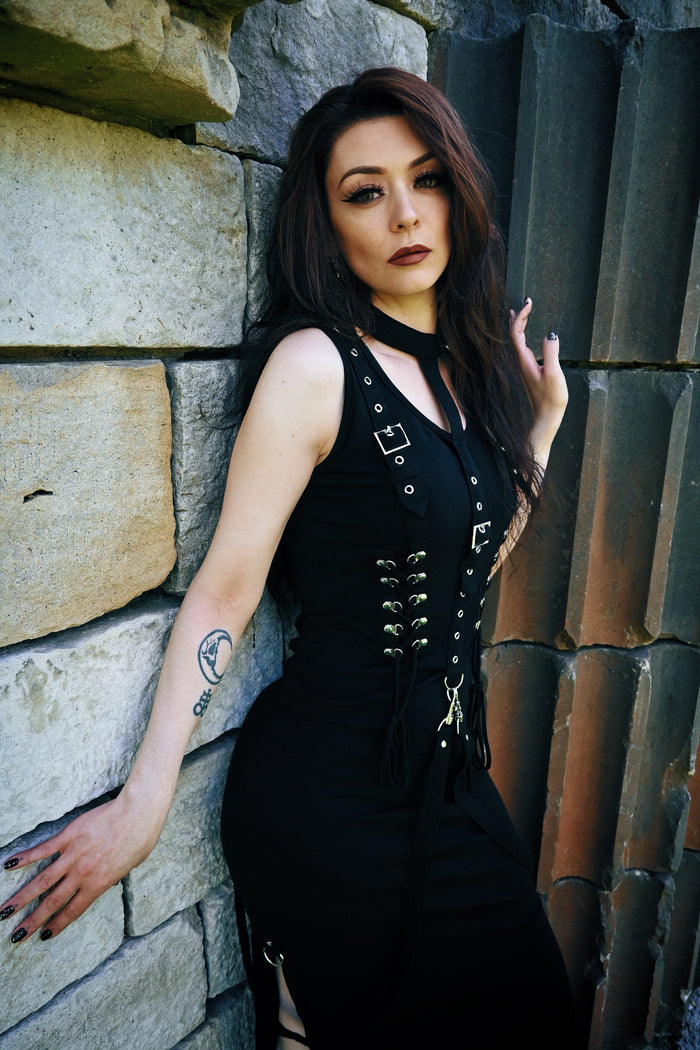 Alternative gothic midi dress in deep black, crafted from a soft and slightly stretchy 95% cotton and 5% elastane blend, featuring a structured attached collar, elegant corset lace detailing on both the front and back for a flattering silhouette, and removable straps that allow for versatile styling options suitable for gothic fashion, alternative outfits, or dark romantic aesthetics.