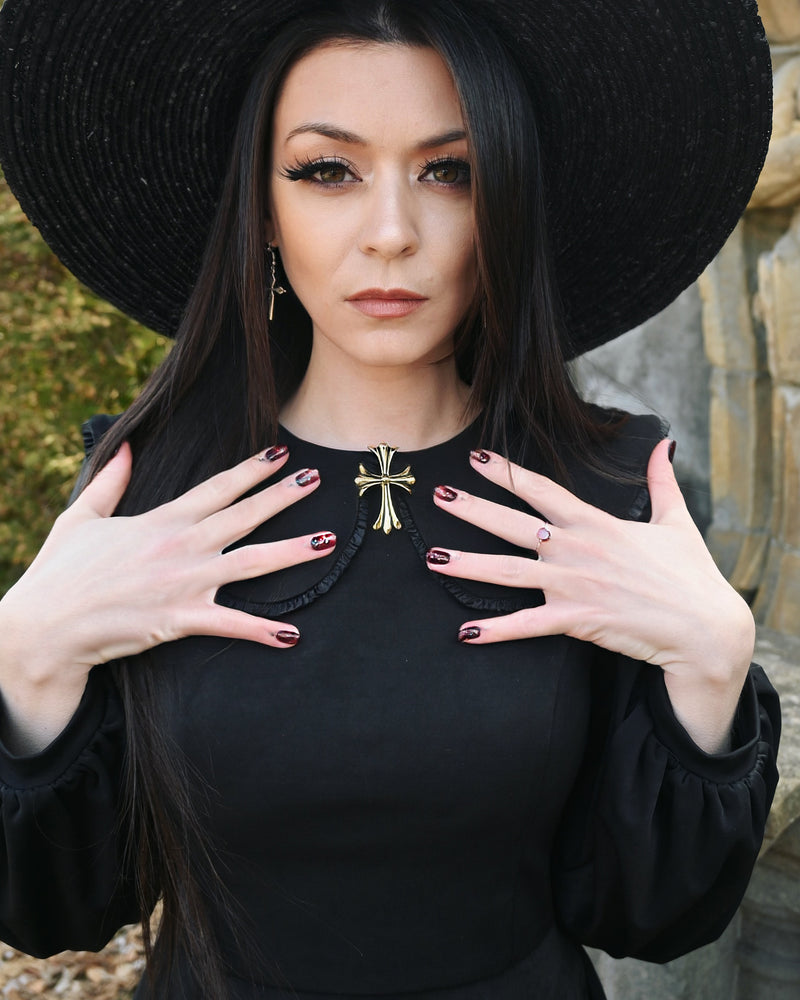 Alt text: Bold baroque gold-tone brooch featuring an ornate gothic cross with flared ends and intricate sculptural detailing. This 2-inch high-shine statement accessory adds a touch of vintage drama to collars, lapels, or cloaks, perfect for layering or wearing solo for a striking look.