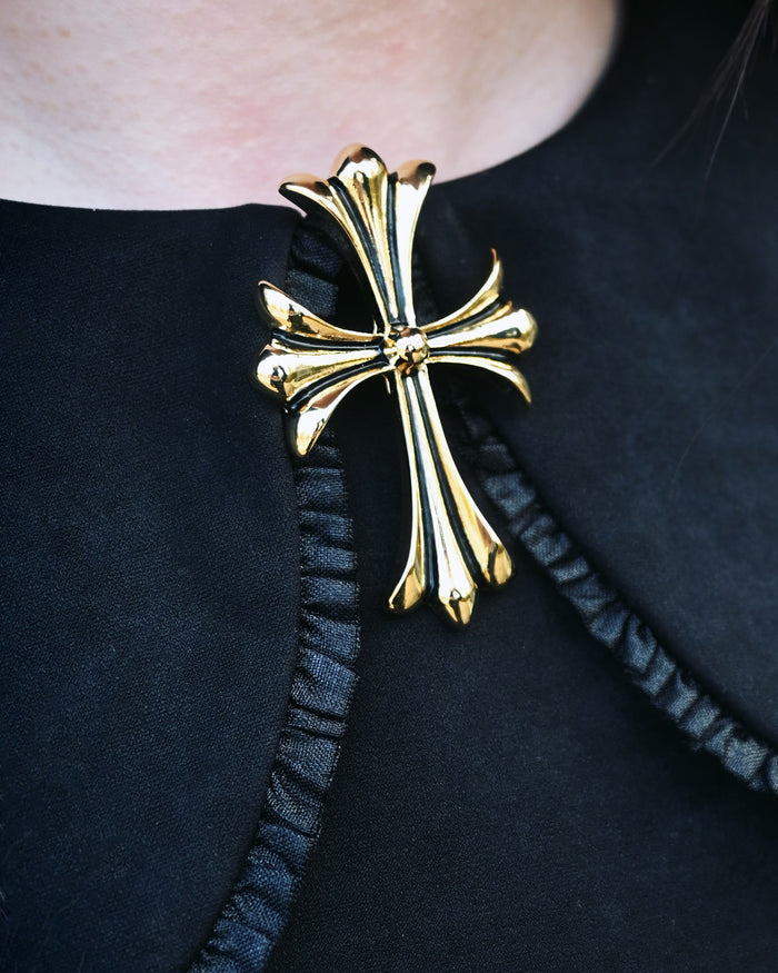 High-shine gold baroque brooch designed in a gothic cross shape with sculptural flared ends. Measuring 2 inches, this ornate accessory brings timeless elegance and bold character to any outfit—ideal for accenting jackets, dresses, or cloaks with dramatic flair.