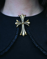 Elegant gold-tone gothic cross brooch with ornate baroque detailing and flared ends. At 2 inches in size, this vintage-inspired statement piece enhances collars, lapels, and cloaks, adding a luxurious and dramatic finishing touch to your ensemble.