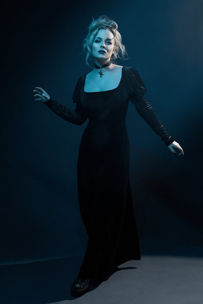 This black velvet Daphne Dress merges vintage Regency inspiration with modern gothic charm. Designed from soft, stretchy polyester velvet, it features a classic empire waist that enhances natural curves, long puffed sleeves for a dramatic silhouette, and a scoop neck that exudes feminine grace. A perfect blend of Victorian allure and dark romantic style for evening wear or elegant alternative fashion.