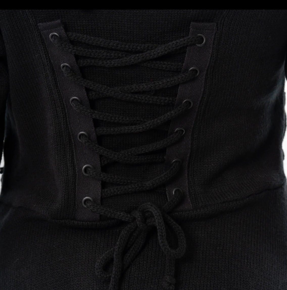 Full-length alternative-style black cardigan with fitted bodice, front and back corset lacing, oversized hood, zip closure, thumbholes, high-low hem, and 100% polyacrylic fabric, offering a dramatic silhouette for gothic or edgy fashion, easily styled for layered or standalone outfits.