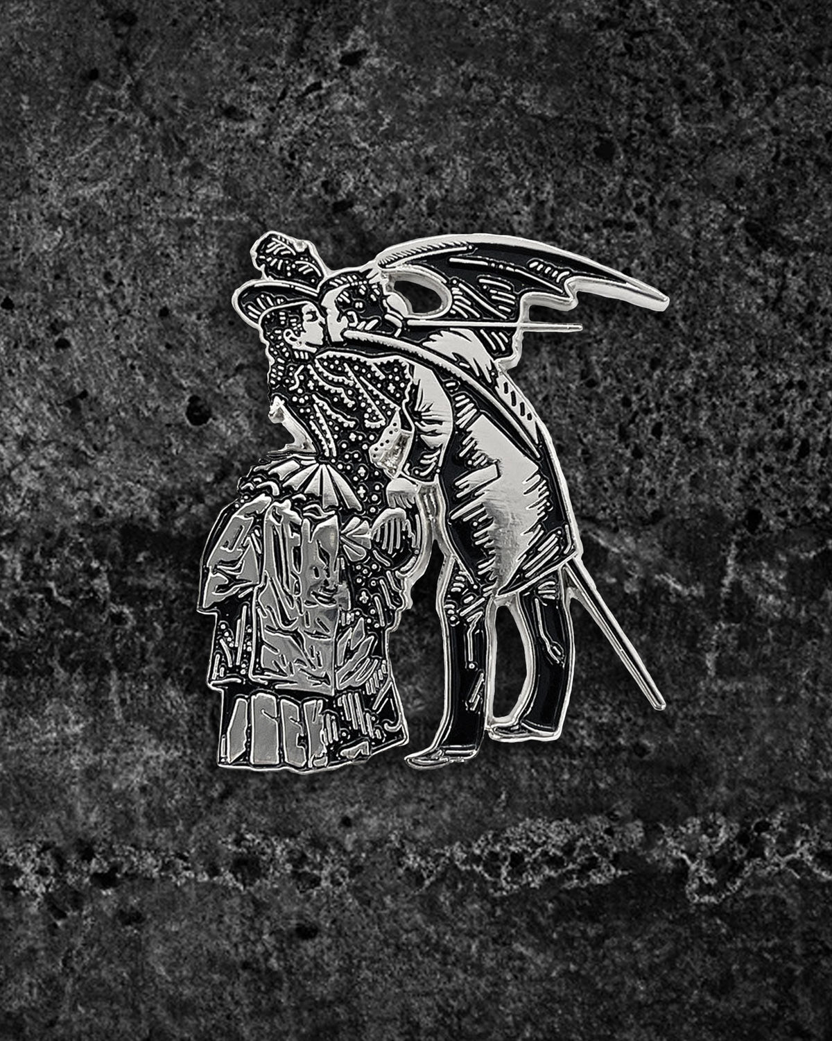 Large silver and black enamel gothic pin inspired by Max Ernst’s surrealist collage from Une Semaine De Bonté, featuring a Victorian-dressed woman kissing a winged man with devilish wings. Measures 2 x 1.71 inches with dual metal clasps to prevent spinning, perfect for jackets, backpacks, or alternative unisex fashion sets.