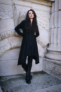 Gothic-inspired Emerson Cardigan by Innocent Lifestyle, made from 100% black polyester, showcasing a soft drape, mid-length cut, zip-up front, side and back corset lacing, elongated hood, and asymmetrical handkerchief hem for versatile styling.