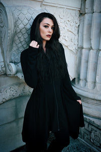Lightweight black Emerson Cardigan by Innocent Lifestyle, designed with soft drape, mid-length fit, zip-up front, elongated hood, and decorative corset lacing at the sides and back, finished with an asymmetrical handkerchief hem for gothic-inspired layering.