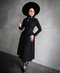 The Homemaker Swing Dress in black is a versatile addition to any wardrobe. Its midi-length design and long sleeves make it suitable for various occasions. The high-stretch Bengaline fabric ensures a comfortable fit, while the hidden front button placket and functional side pockets add functional details. The flared skirt creates a dramatic silhouette, embodying Gothic romance and timeless elegance.