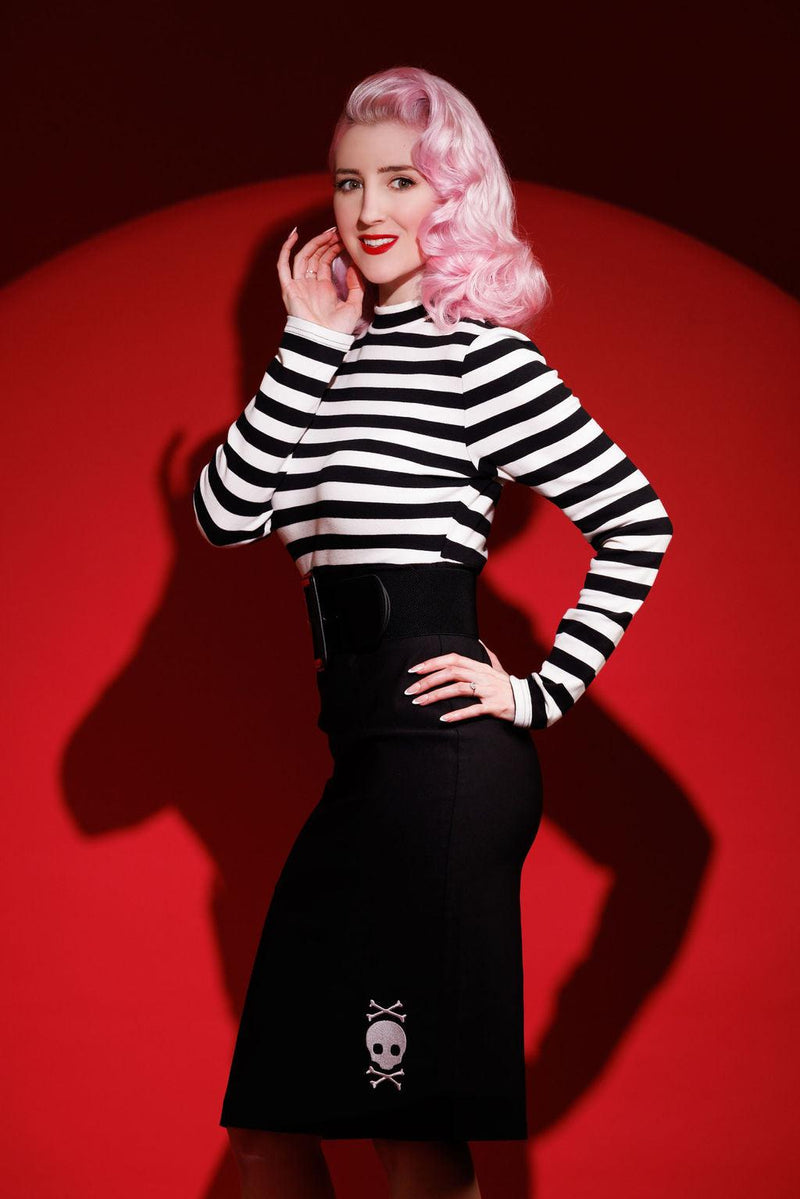 Alternative fashion dress with striped top and embroidered skull detailing, the Jailhouse Dress offers a figure-hugging shape in soft bengaline fabric, balancing edgy rebellious design with comfort, available in black or red for a bold statement outfit.