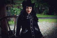 June Dress in black and white with a flattering skater skirt cut, intricately embroidered roses and thorns across the collar, cuffs, bust, and hips, subtle white piping along the seams, long piped sleeves with faux snap cuffs, and functional deep pockets, designed for women seeking both elegance and practicality in one versatile dress.