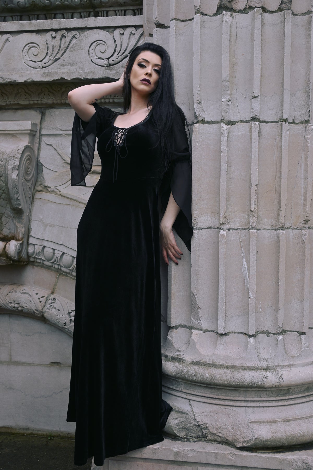 A luxurious Gothic-inspired medieval maxi dress crafted from rich velvet, featuring a corset lace bust for a flattering silhouette, black sheer chiffon long sleeves for an elegant and mysterious look, and a stretchy fit that combines comfort with authentic medieval style, perfect for cosplay, renaissance fairs, or romantic themed events.