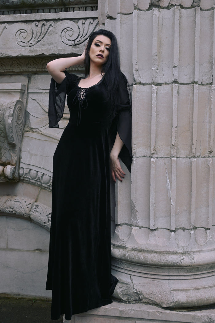 A luxurious Gothic-inspired medieval maxi dress crafted from rich velvet, featuring a corset lace bust for a flattering silhouette, black sheer chiffon long sleeves for an elegant and mysterious look, and a stretchy fit that combines comfort with authentic medieval style, perfect for cosplay, renaissance fairs, or romantic themed events.