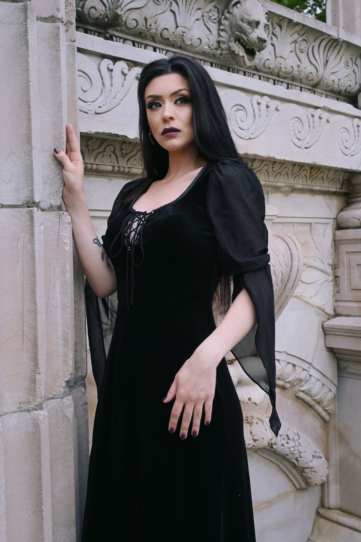 Darkly elegant velvet medieval dress with intricate corset lace detailing at the bust, flowing black chiffon sleeves that add a touch of mystique, and a comfortable stretchy design, ideal for Gothic fashion lovers, cosplay enthusiasts, or anyone seeking a dramatic and timeless medieval-inspired outfit.