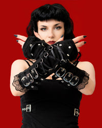 Woman wearing black lace gloves with buckles against a red background