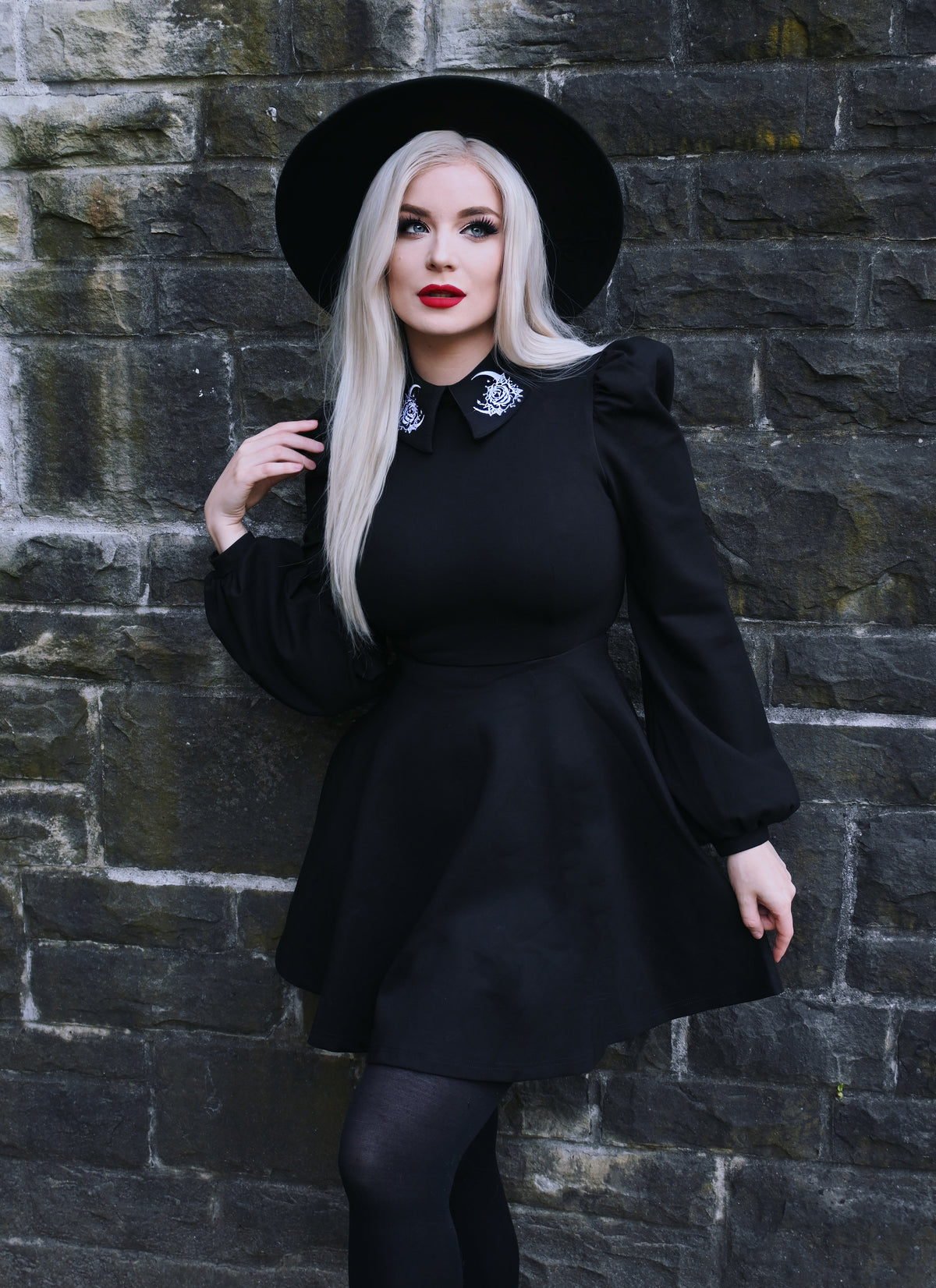 Luxurious black Moon Flower Dress designed with a distinctive embroidered collar featuring white moon and floral motifs, styled with voluminous puff shoulders and elegant bishop sleeves, all constructed from a premium thick ponte fabric ideal for comfortable wear in fall or winter.