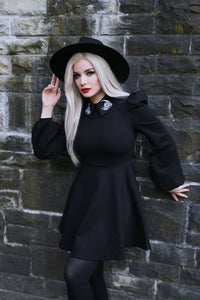 Stylish and unique Moon Flower Dress in black ponte fabric featuring exquisite white embroidery of a moon and flower on its wide collar, enhanced by puffed shoulders and graceful bishop sleeves, merging comfort, elegance, and celestial-inspired details perfect for evening or seasonal wear.