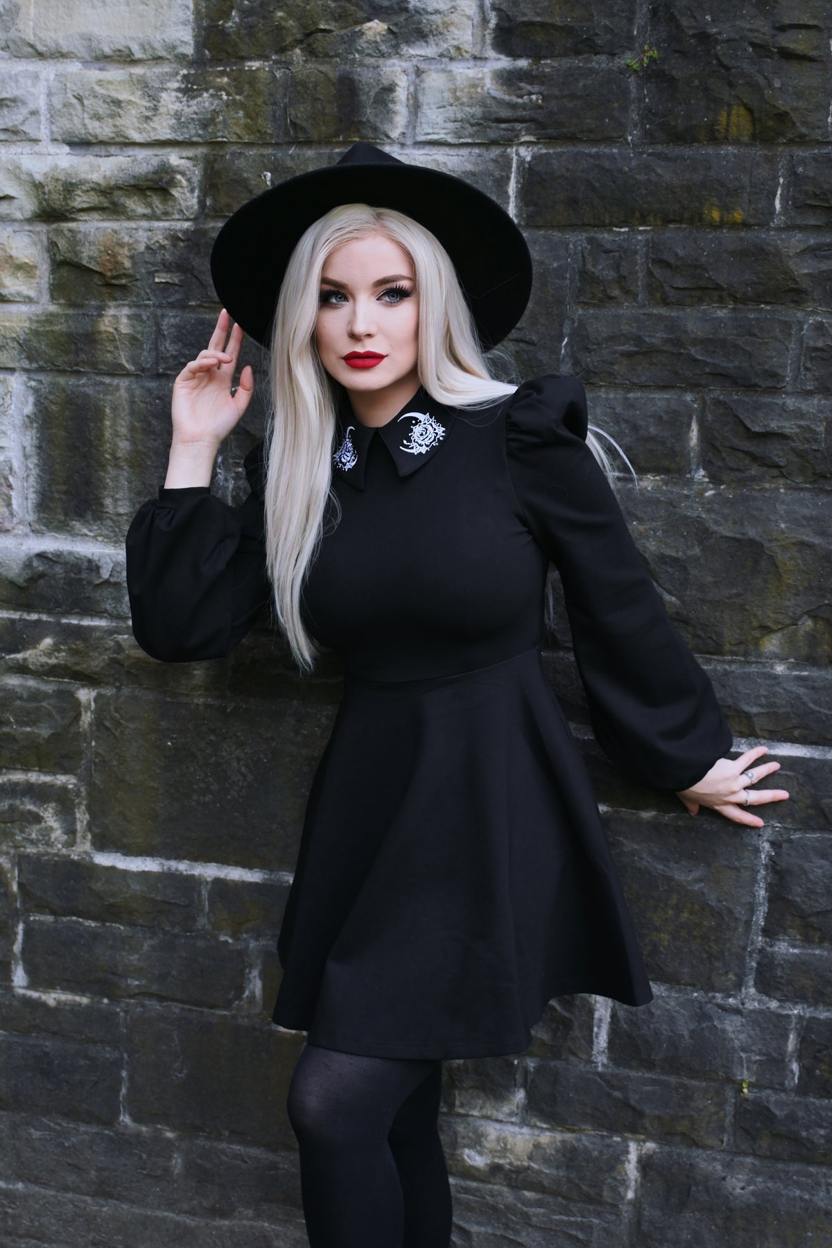 Black Moon Flower Dress crafted for comfort and drama, made with stretchy, thick ponte fabric and highlighted by an embroidered white moon and flower design on the collar, along with puff shoulders and bishop sleeves that evoke a vintage-inspired, celestial aesthetic.
