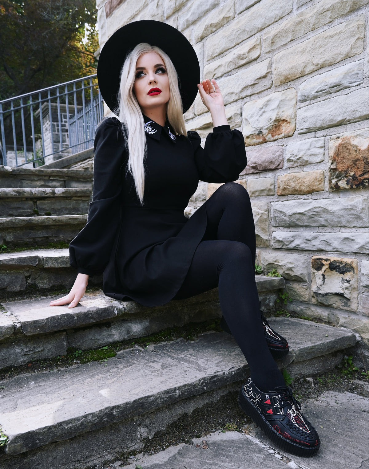 The Moon Flower Dress presents a captivating blend of gothic and romantic design with its black ponte construction, puff shoulders, bishop sleeves, and beautifully embroidered white moon and flower embellishments on a wide collar, ideal for cooler weather styling.