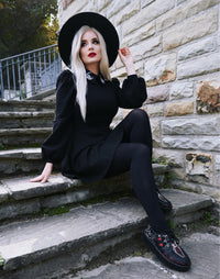 The Moon Flower Dress presents a captivating blend of gothic and romantic design with its black ponte construction, puff shoulders, bishop sleeves, and beautifully embroidered white moon and flower embellishments on a wide collar, ideal for cooler weather styling.